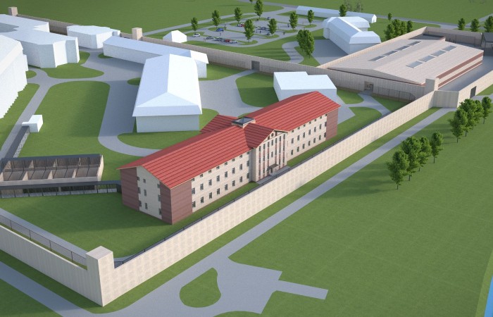 In the photo, Radom penitentiary facility’ visualisation with a group of buildings of different shapes surrounded by the fence and lots of trees and greenery. In the photo, Radom penitentiary facility’ visualisation with a group of buildings of different shapes surrounded by the fence and lots of trees and greenery.