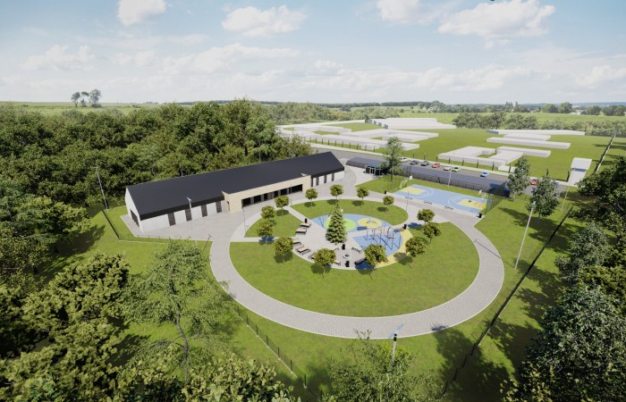 In the photo, a bird’s-eye view visualisation of the Jastrzębie-Zdrój halfway house. In the middle, you can see an elongated building with a round driveway. On the right-hand side, car park and sports field. All surrounded by trees and green. In the photo, a bird’s-eye view visualisation of the Jastrzębie-Zdrój halfway house. In the middle, you can see an elongated building with a round driveway. On the right-hand side, car park and sports field. All surrounded by trees and green.