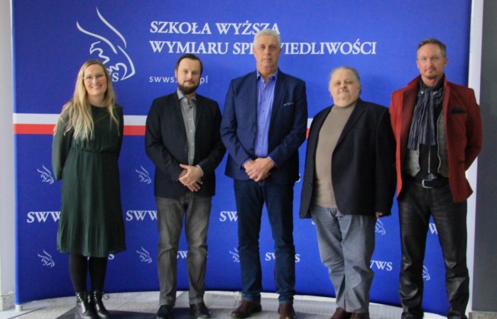 Five persons are posing for a photo against the blue panel of the Academy of Justice. Five persons are posing for a photo against the blue panel of the Academy of Justice.