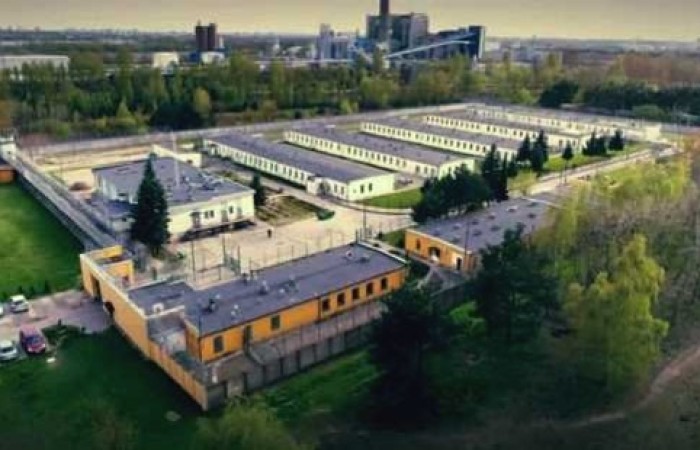 Fotografia przedstawia Zakład Karny w Koziegłowach widziany z lotu ptaka. Widać kompleks budynków oddzielony ogrodzeniem. Z jednej i drugiej jego strony drzewa. Fotografia przedstawia Zakład Karny w Koziegłowach widziany z lotu ptaka. Widać kompleks budynków oddzielony ogrodzeniem. Z jednej i drugiej jego strony drzewa.